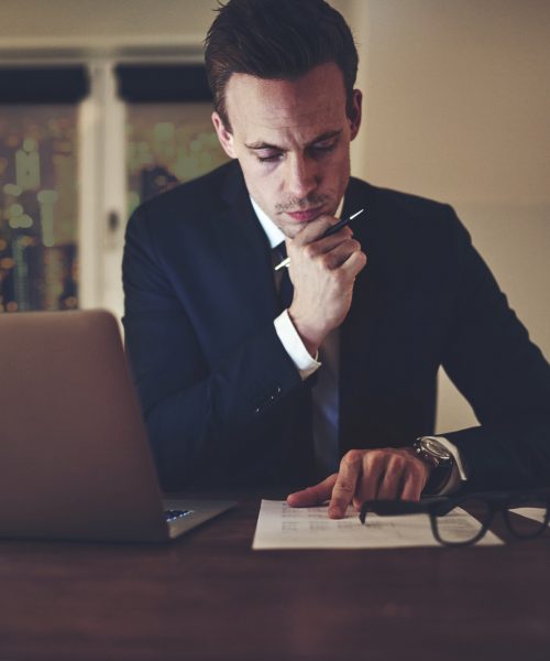 Pensive office worker accounting in the evening Pensive office worker accounting in the evening